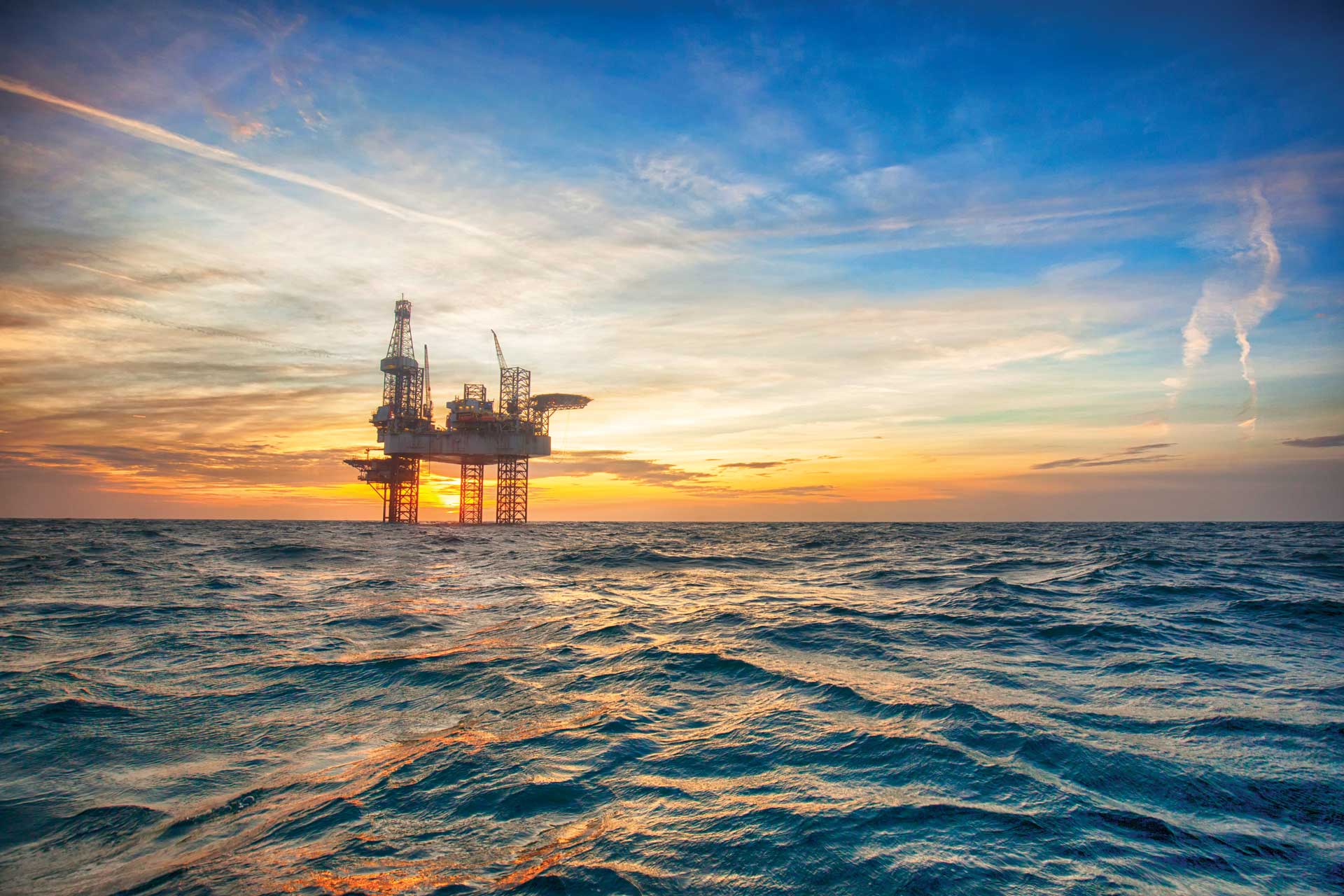 an ocean oil rig at sunset
